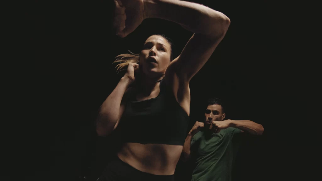 Pareja de mujer y hombre practicando body combat 100 en un gimnasio en bogota y colombia